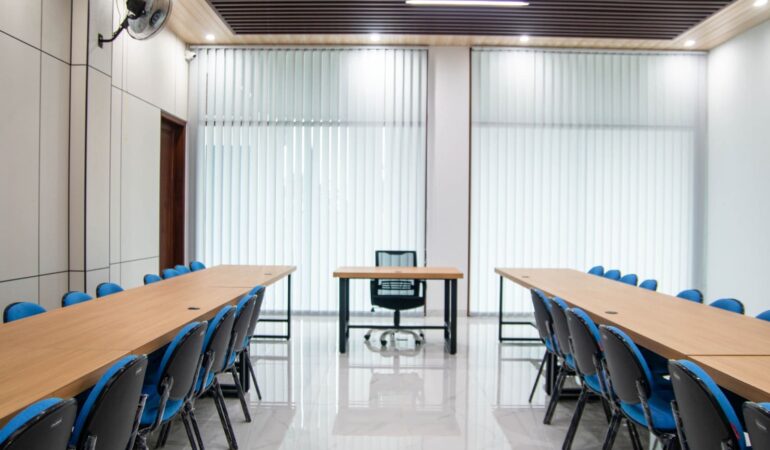 Desain ruang meeting kantor distributor modern dengan meja konfigurasi U dan aksen kayu